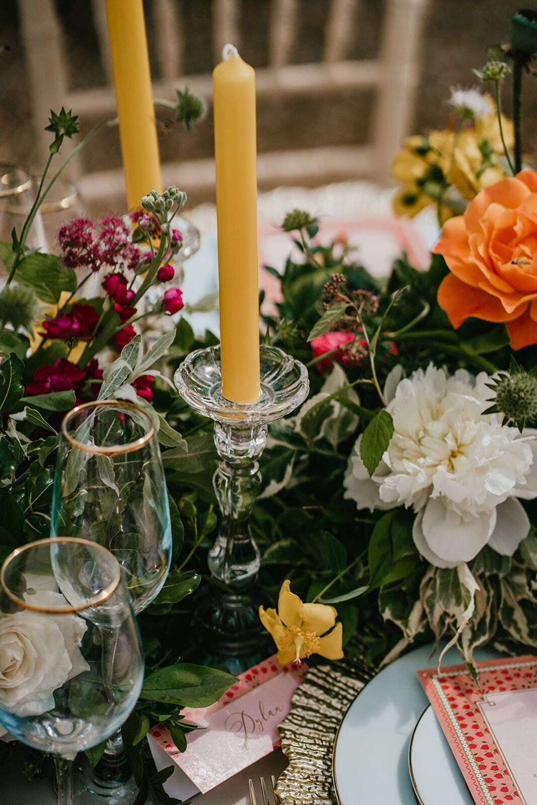 Yellow candles in glass vintage candlestick on a wedding table with flowers