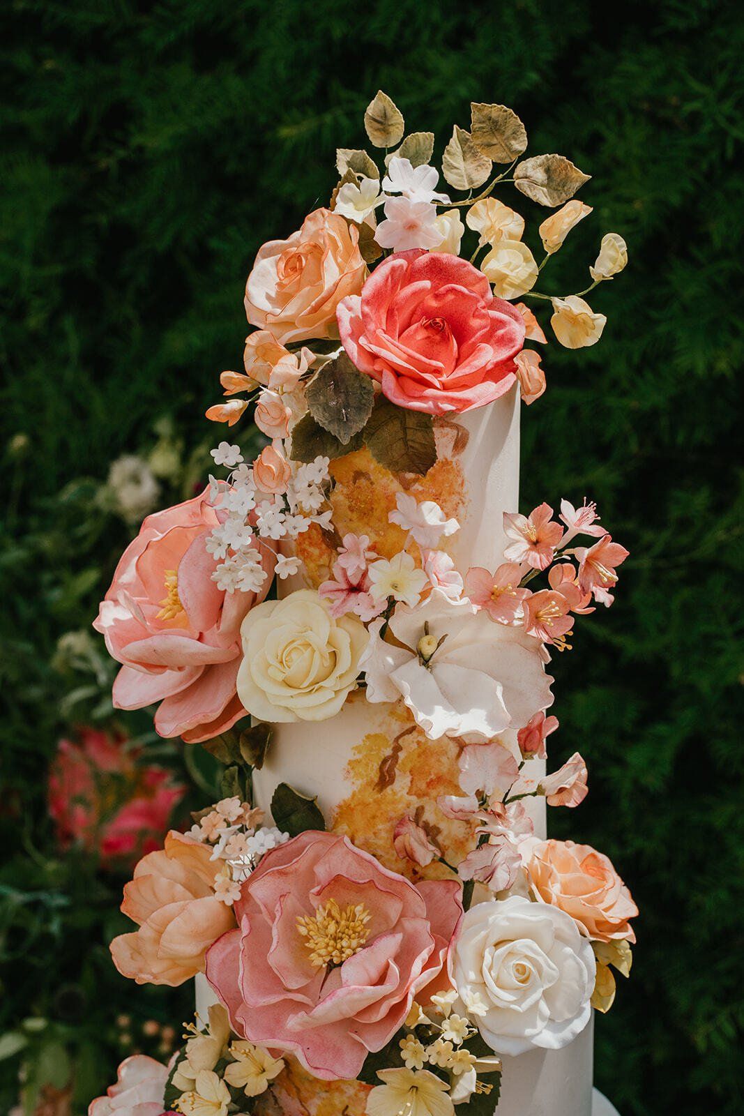 Colourful wedding cake with peach and cream sugar flower peonies