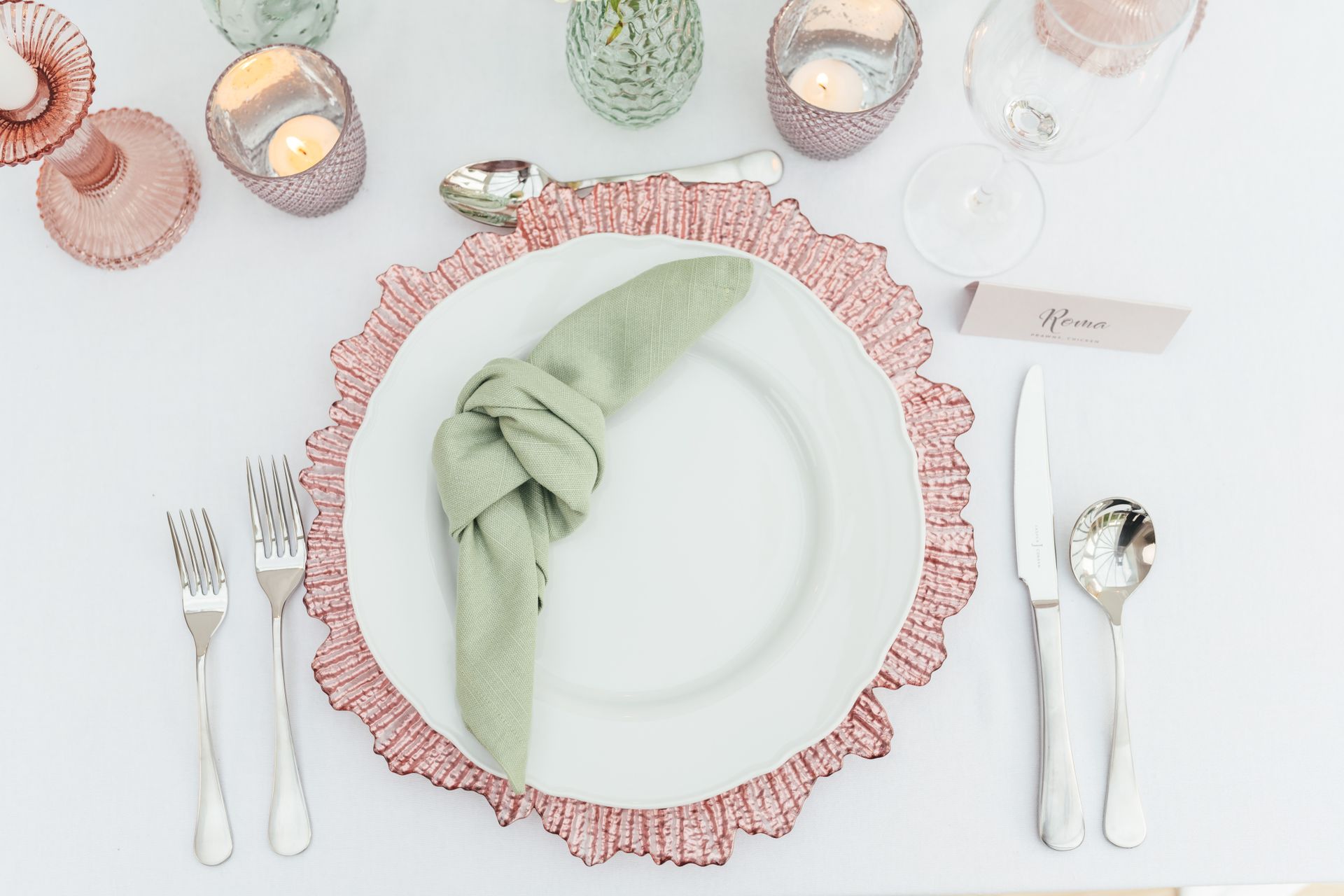 Pink reef charger plate with white dinner plate and light green napkin