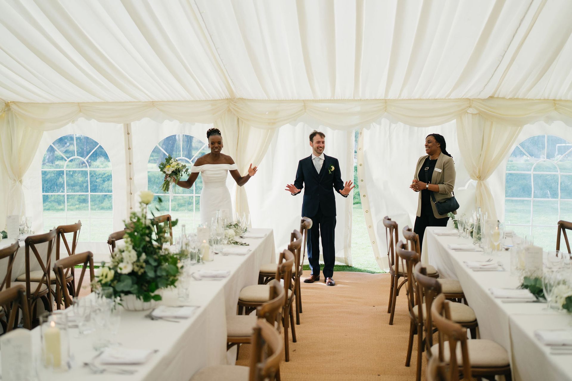 The bride and groom walking into their wedding reception marquee and smiling with joy