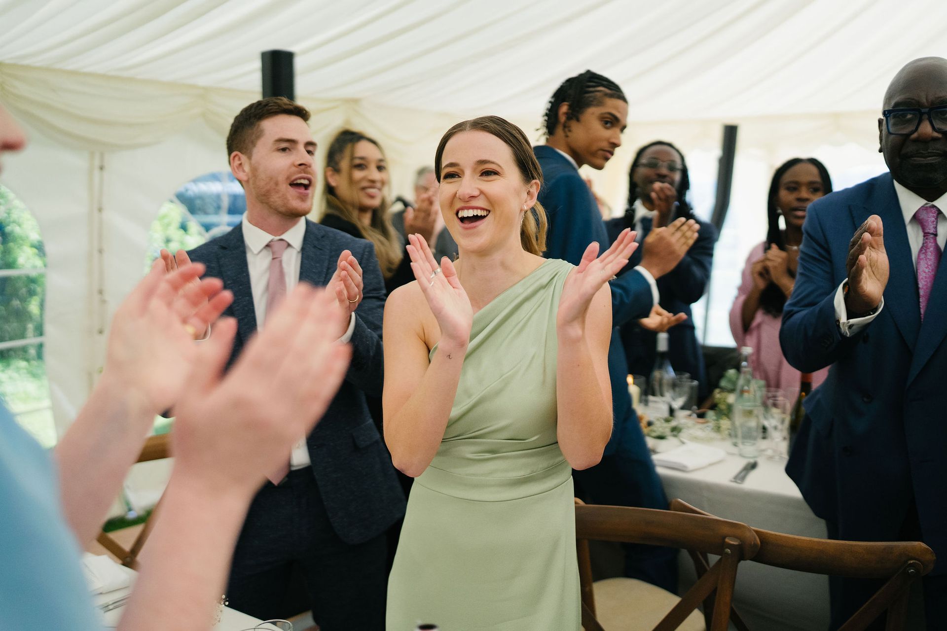 bridesmaid in green dress smiling and clapping her hands
