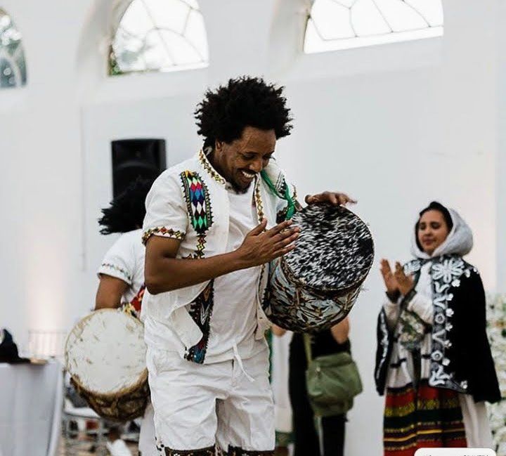 Ethiopian drummer smiling and hitting drum