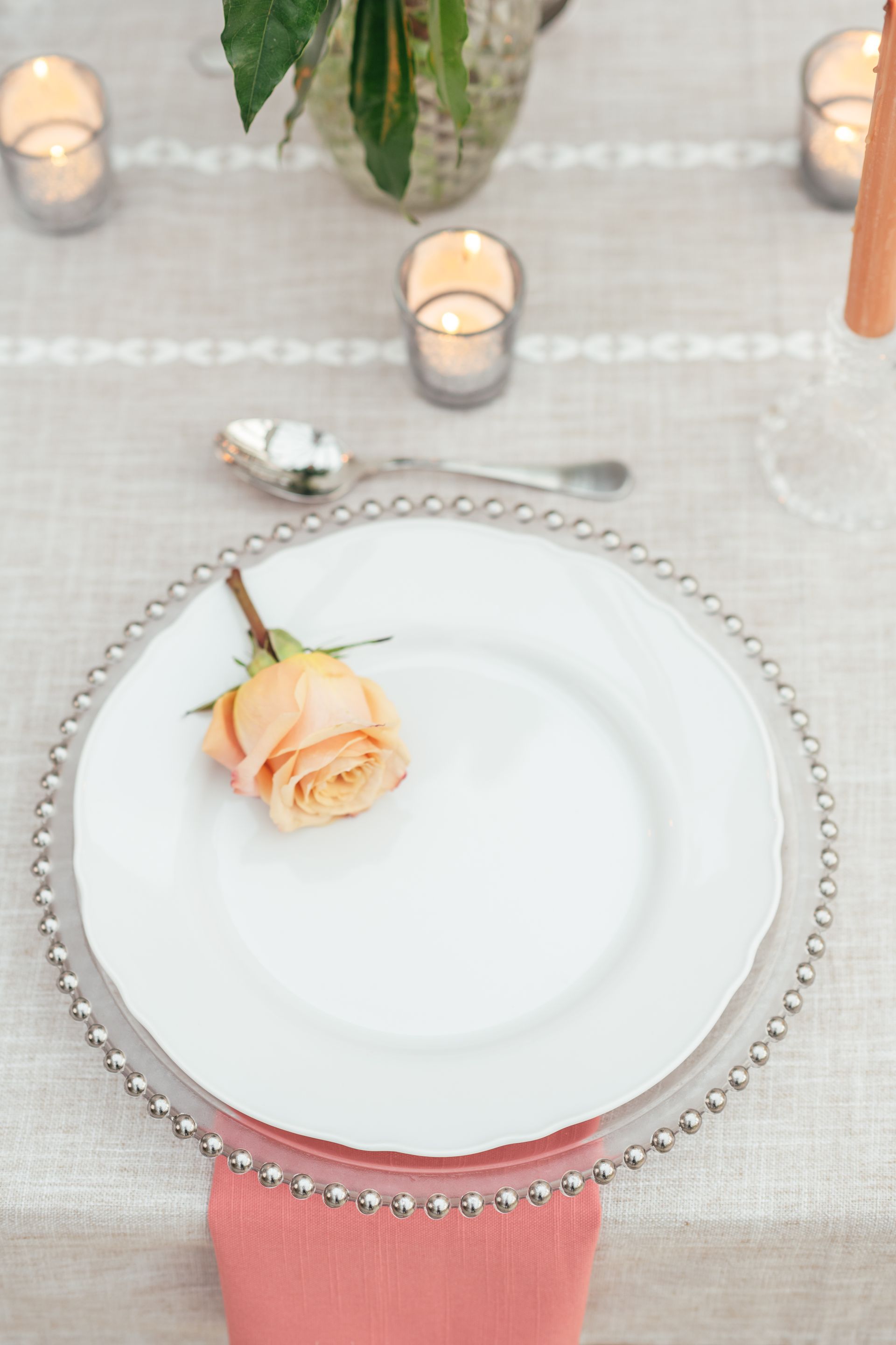 Silver glass beaded charger plate with white plate with peach rose on it