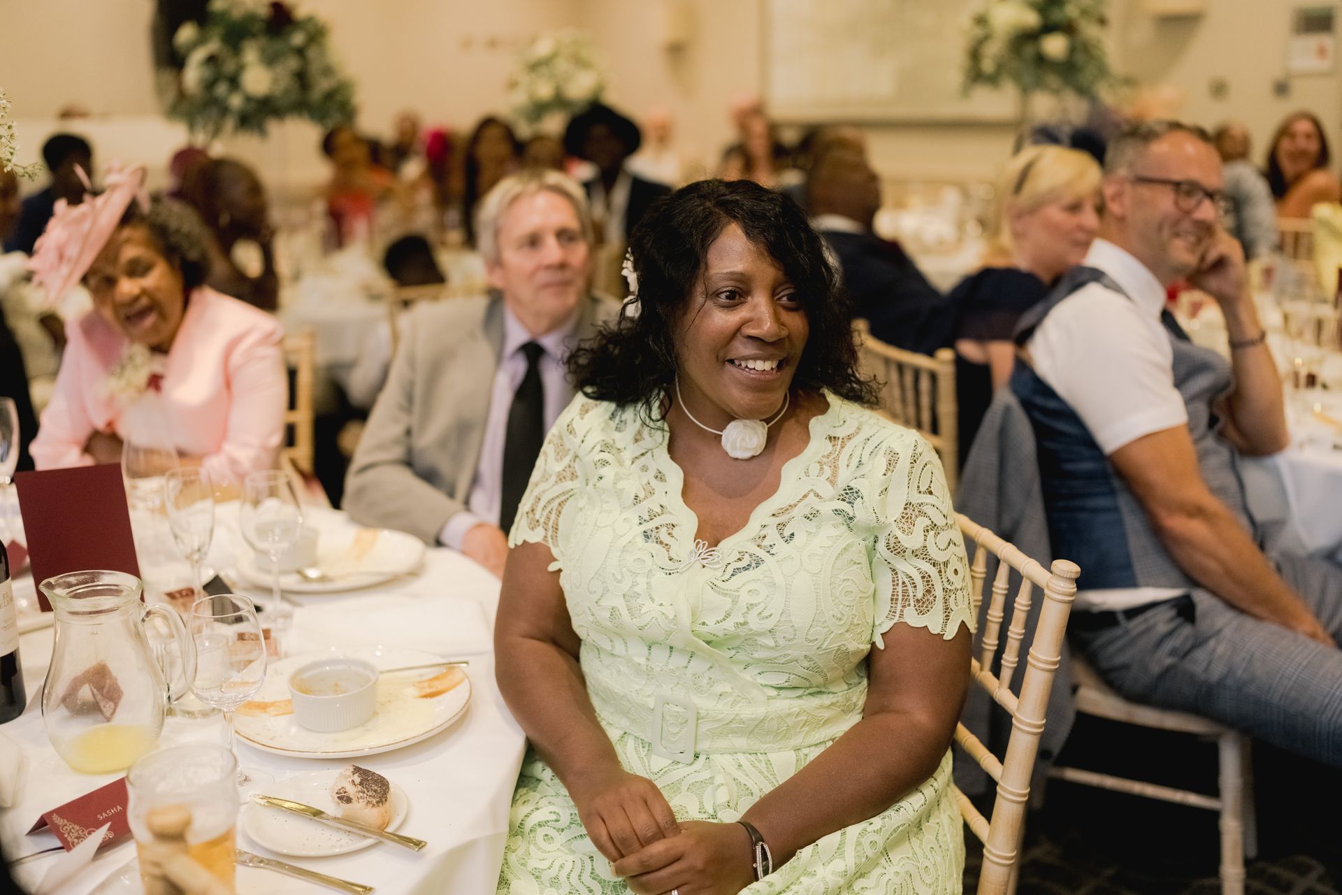 Wedding guests sitting round a table and smiling