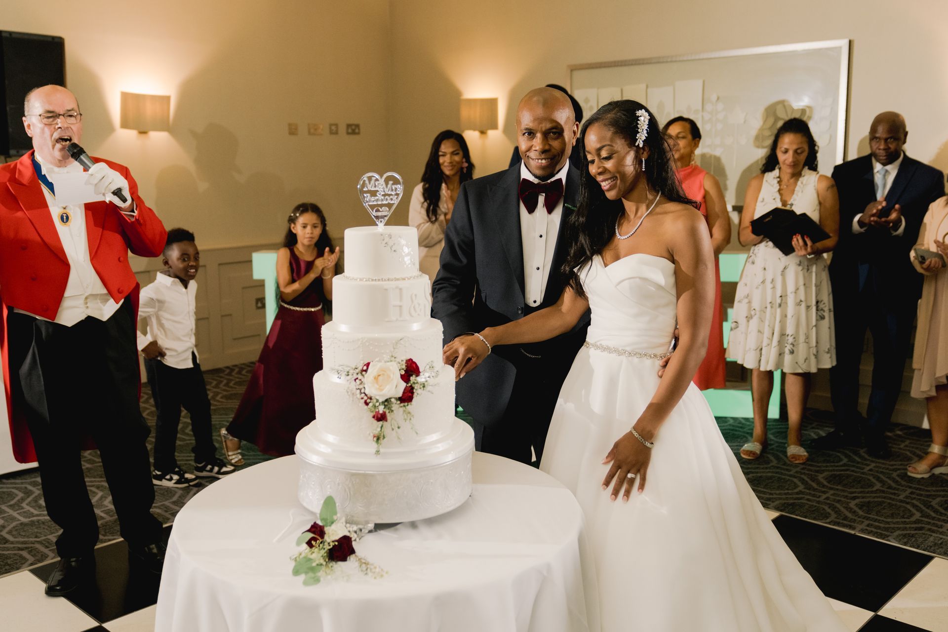 Black bride and groom standing and cutting wedding cake