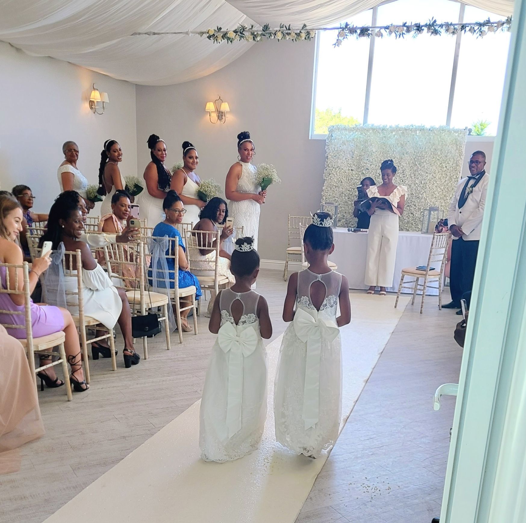 Young black boy in a mini black Mercedes driving down a wedding aisle