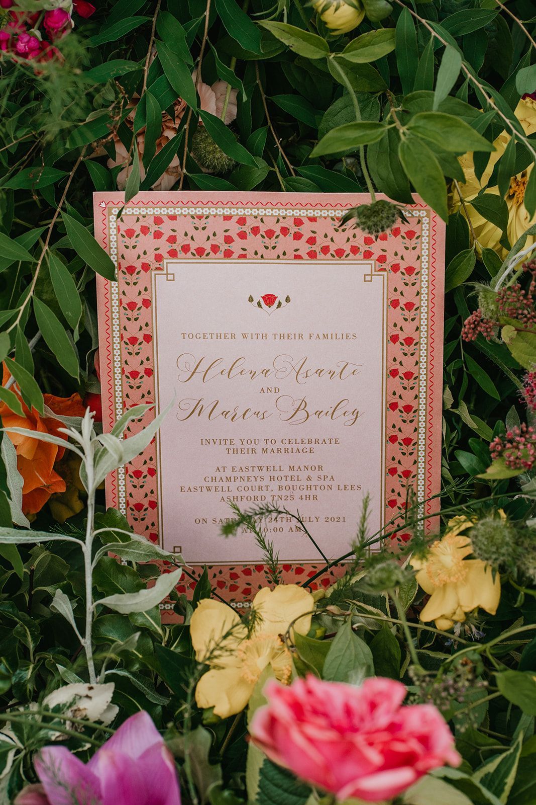 Peach wedding Invitation with an orange frame placed in yellow peach flowers