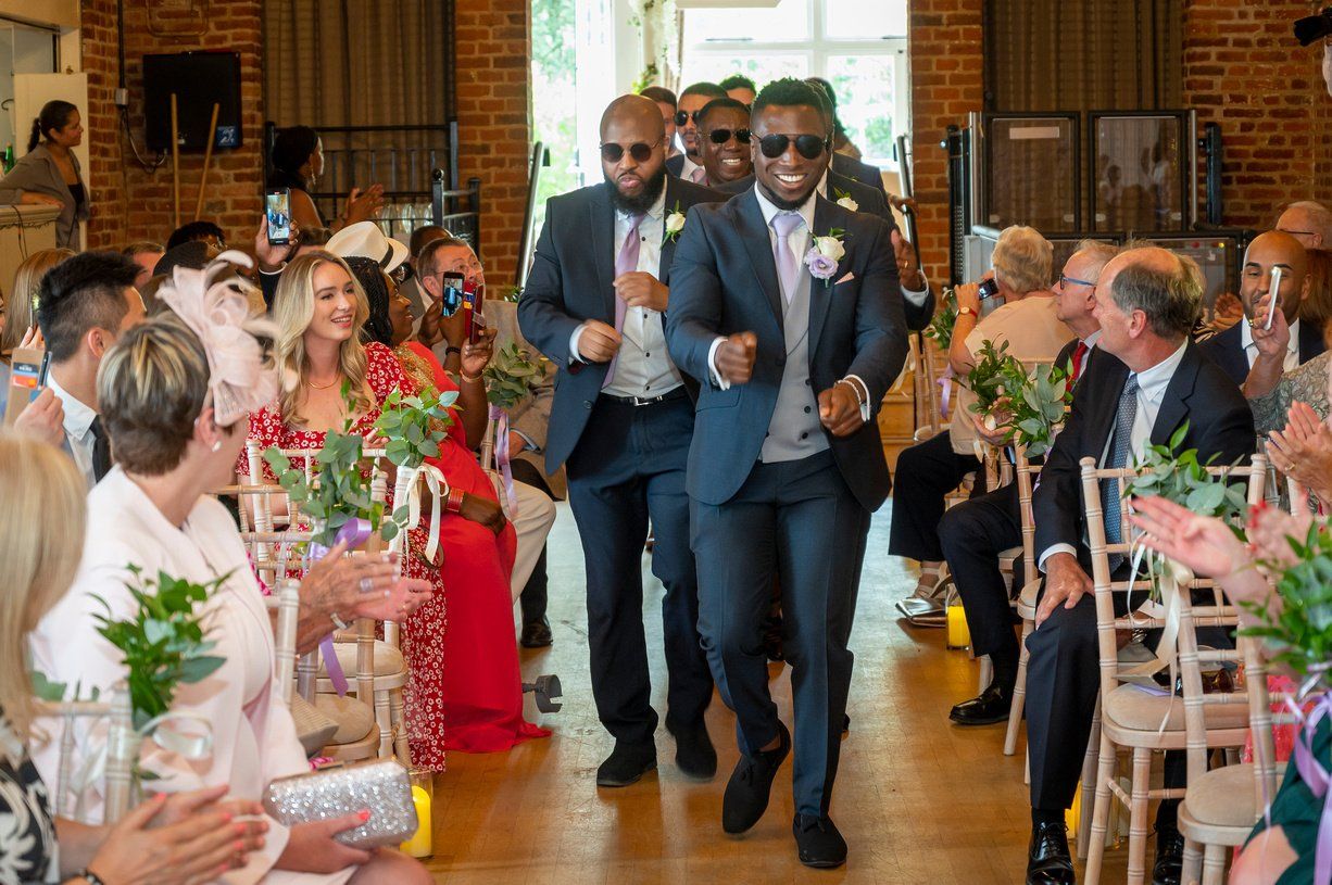 Grooms procession fusion wedding black groom and groomsmen dancing down aisle