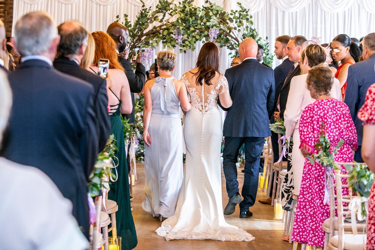 Back view of Bride walking down the aisle with her parents