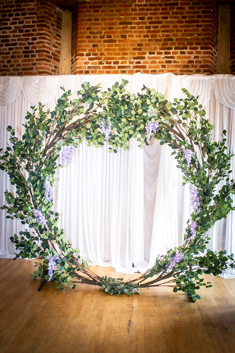 Eucalyptus moongate with lilac wisteria against a white backdrop