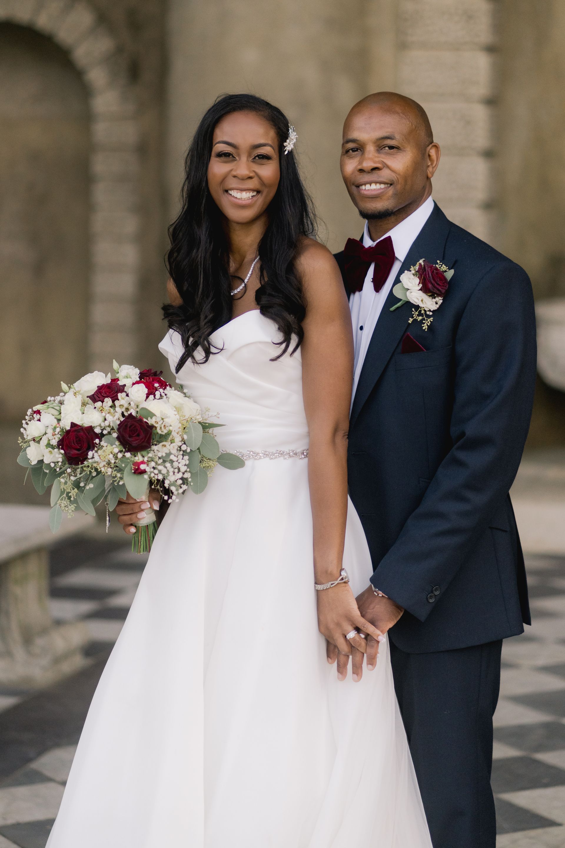 Black bride and groom standing in grounds of Wotton House and smiling at camera