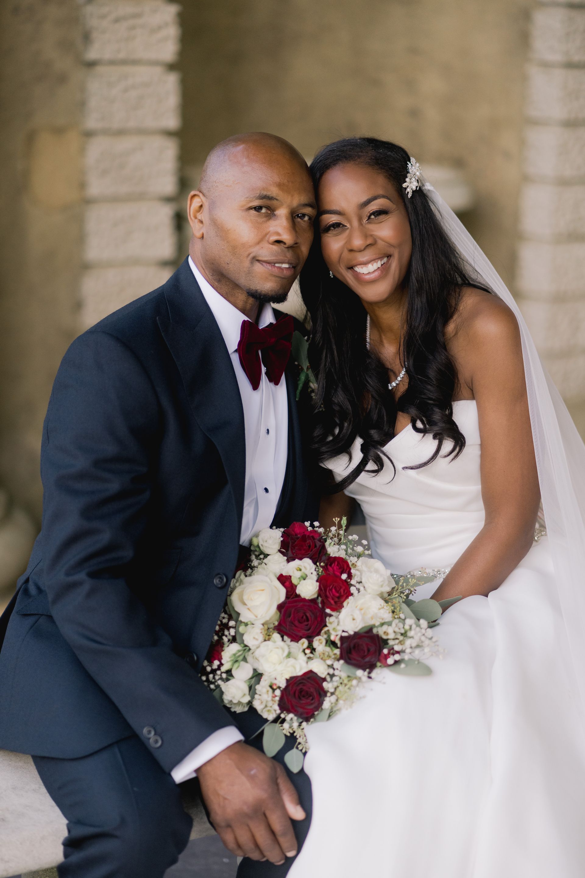Black bride and groom seated in Wotton House Hotel and smiling to camera