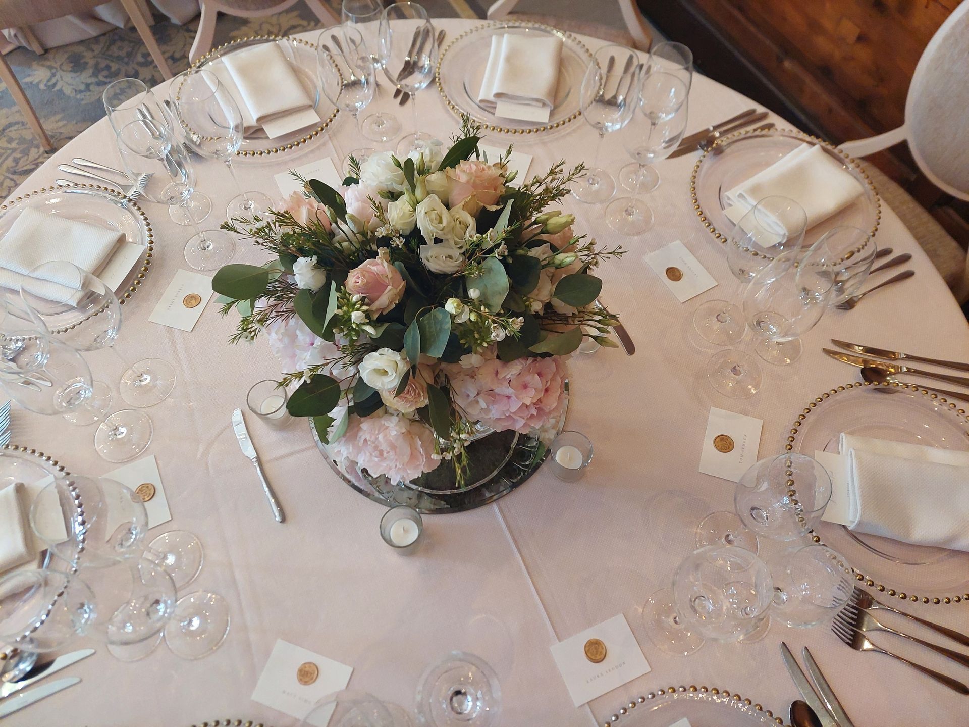 Birds eye view of a round wedding table with pink and white flower centrepieces