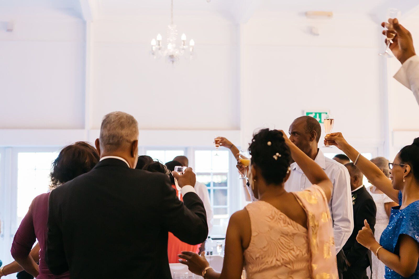 Wedding guests raising a glass to cheers the couple