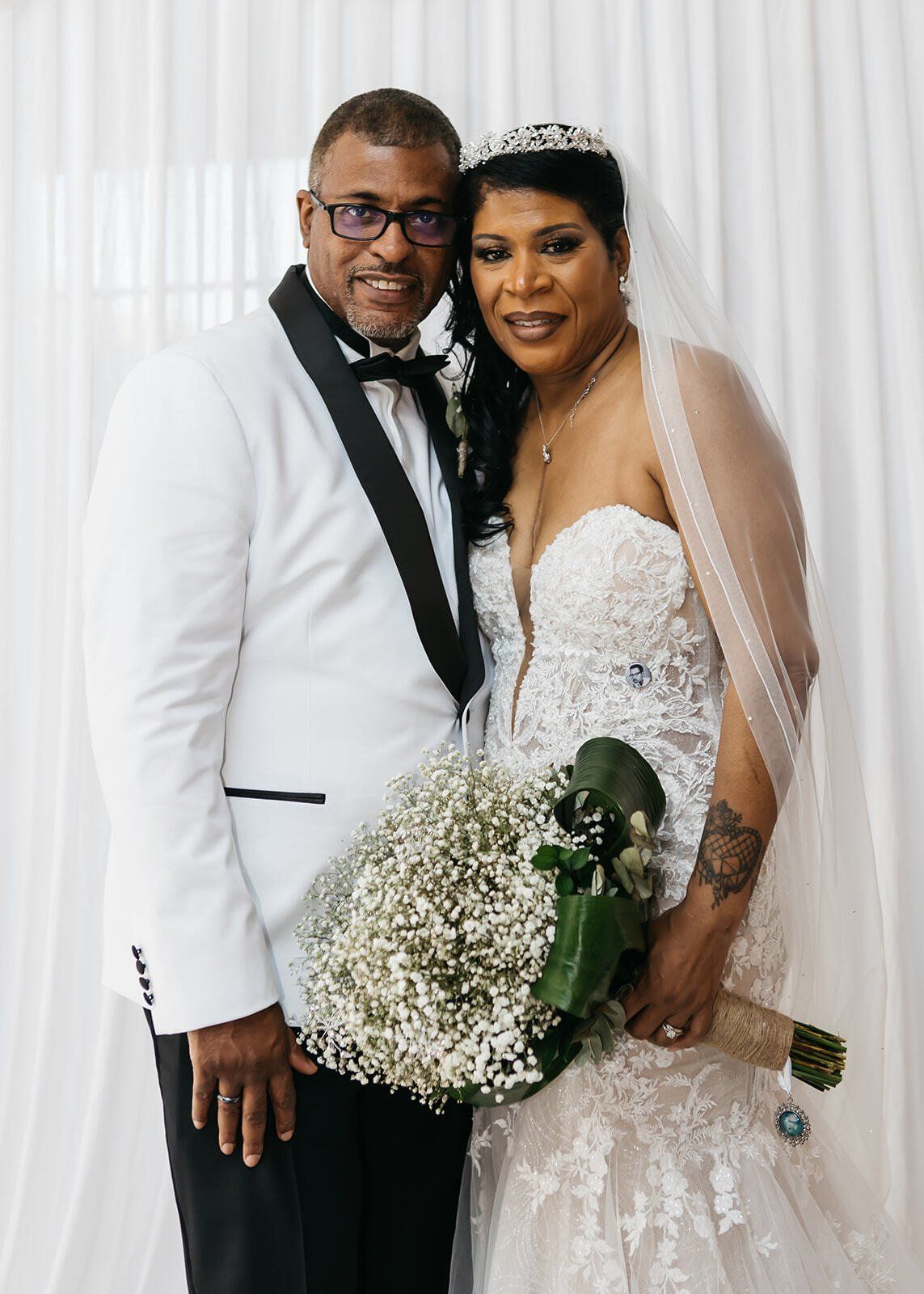 Black bride and groom smiling together and looking at camera