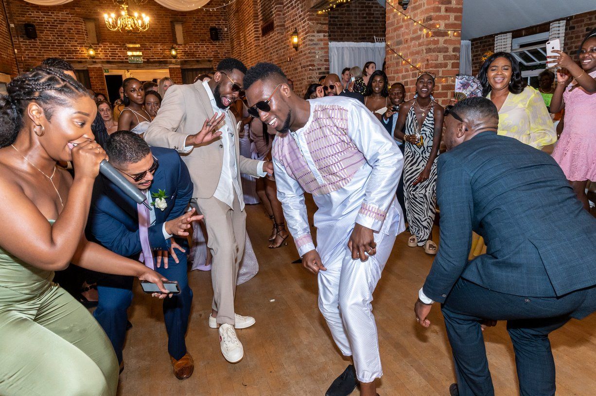 Black groom fusion Ghanaian Italian wedding dancing in traditional dress
