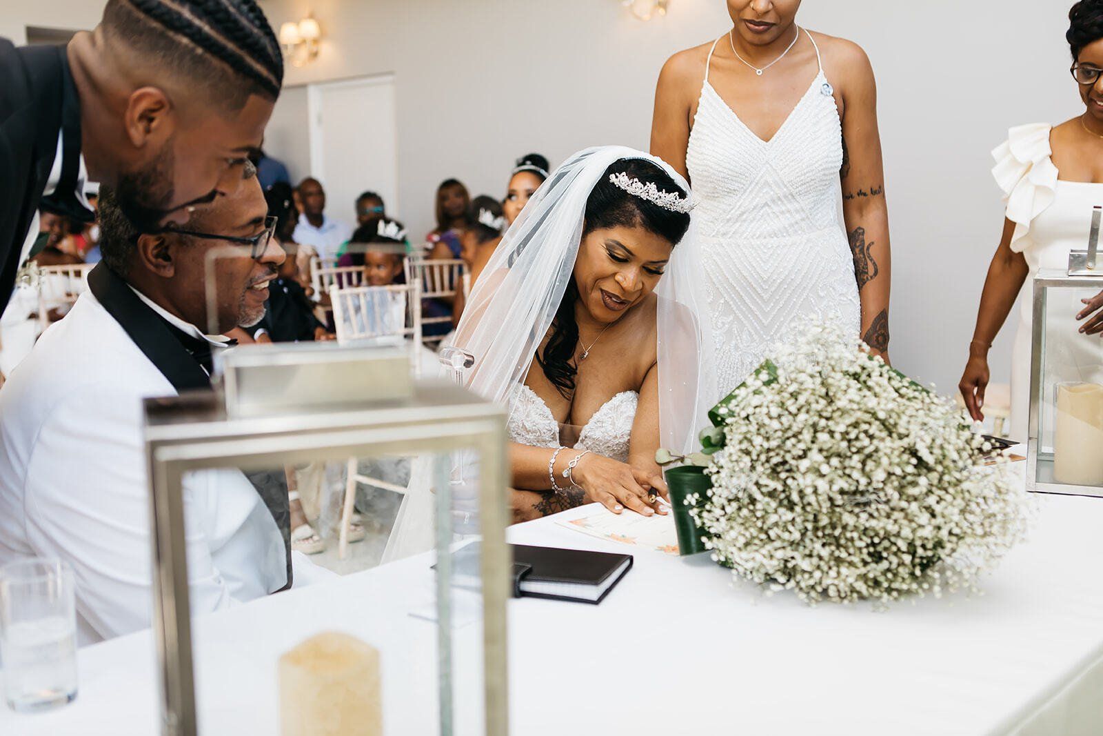 Black bride seated and signing wedding register