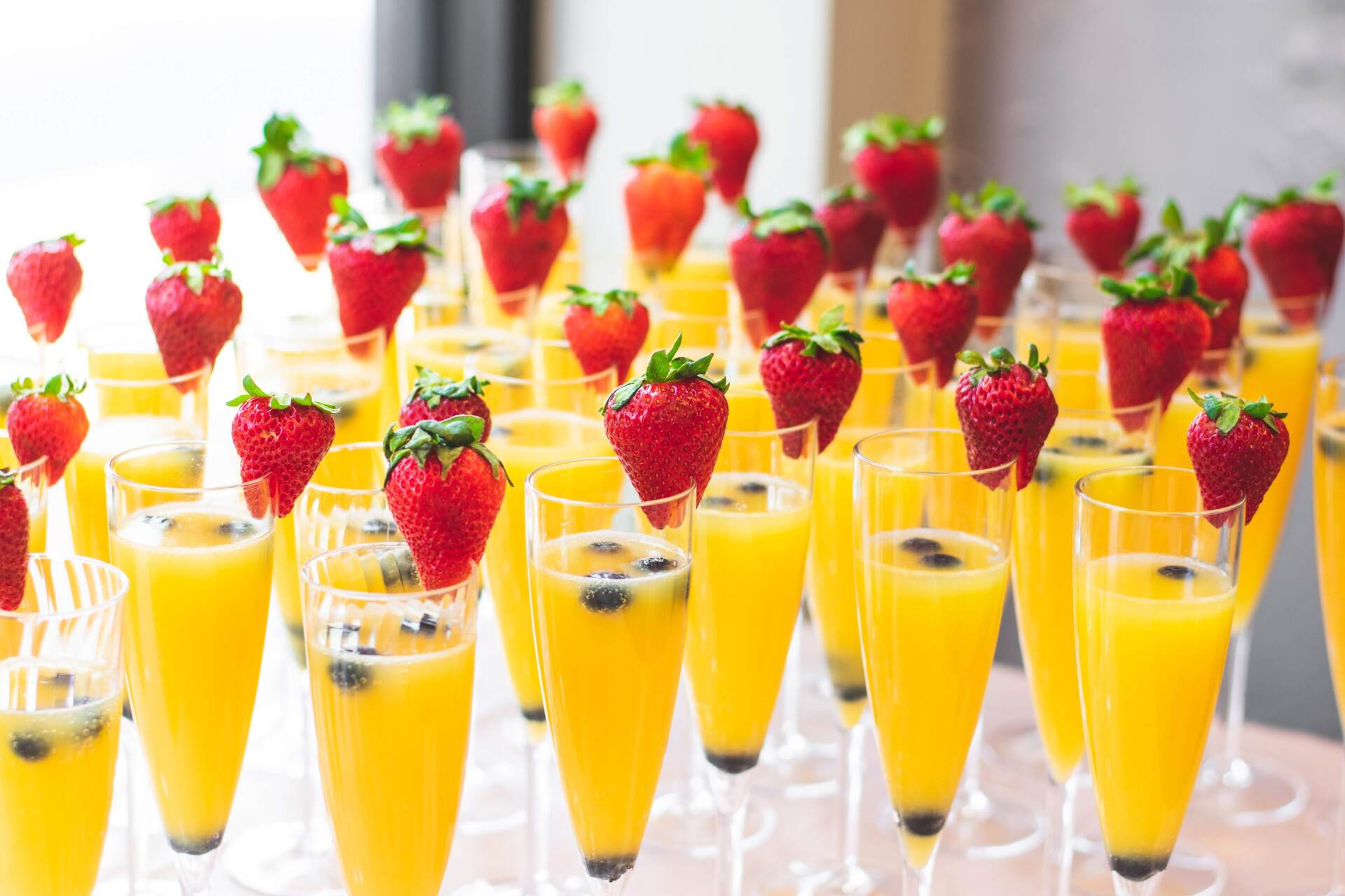 Yellow cocktails with strawberry on top of glass