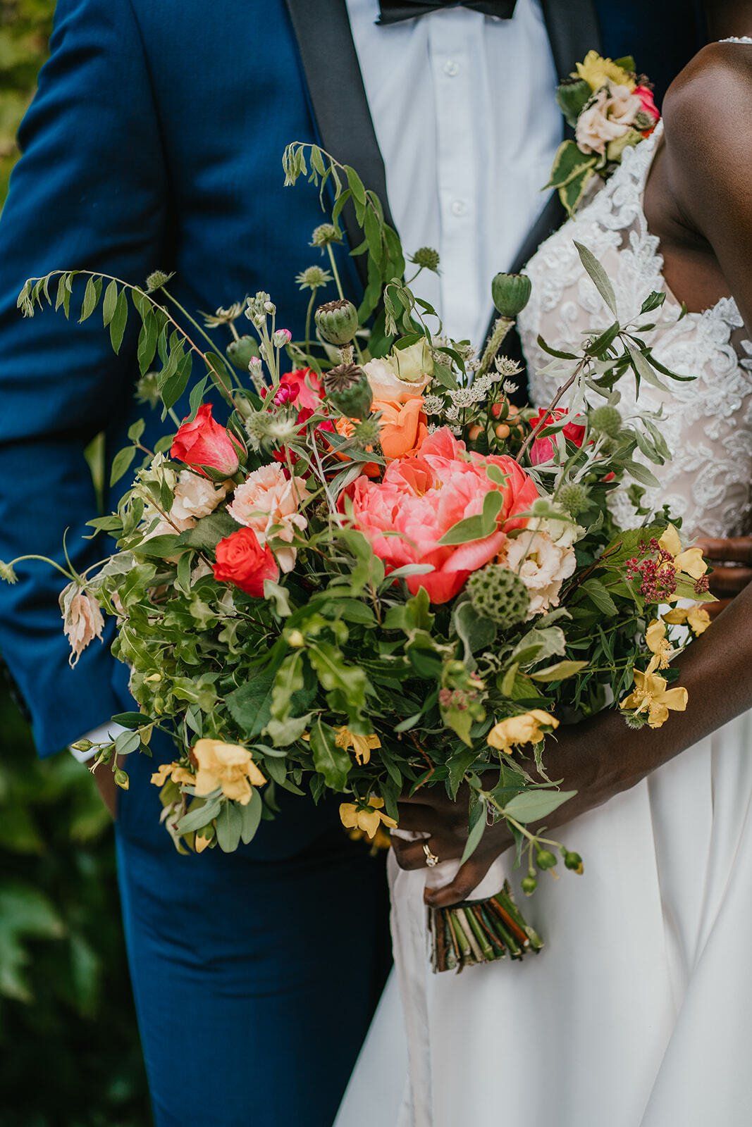 Bright bridal bouquet with orange peonies and foliage