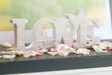 Love letters in white surrounded by pink and cream rose petals