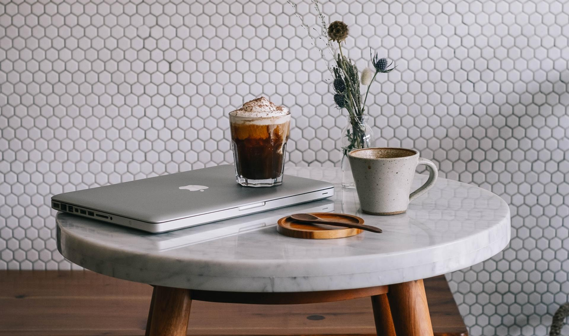 table with computer and coffee and plant on it
