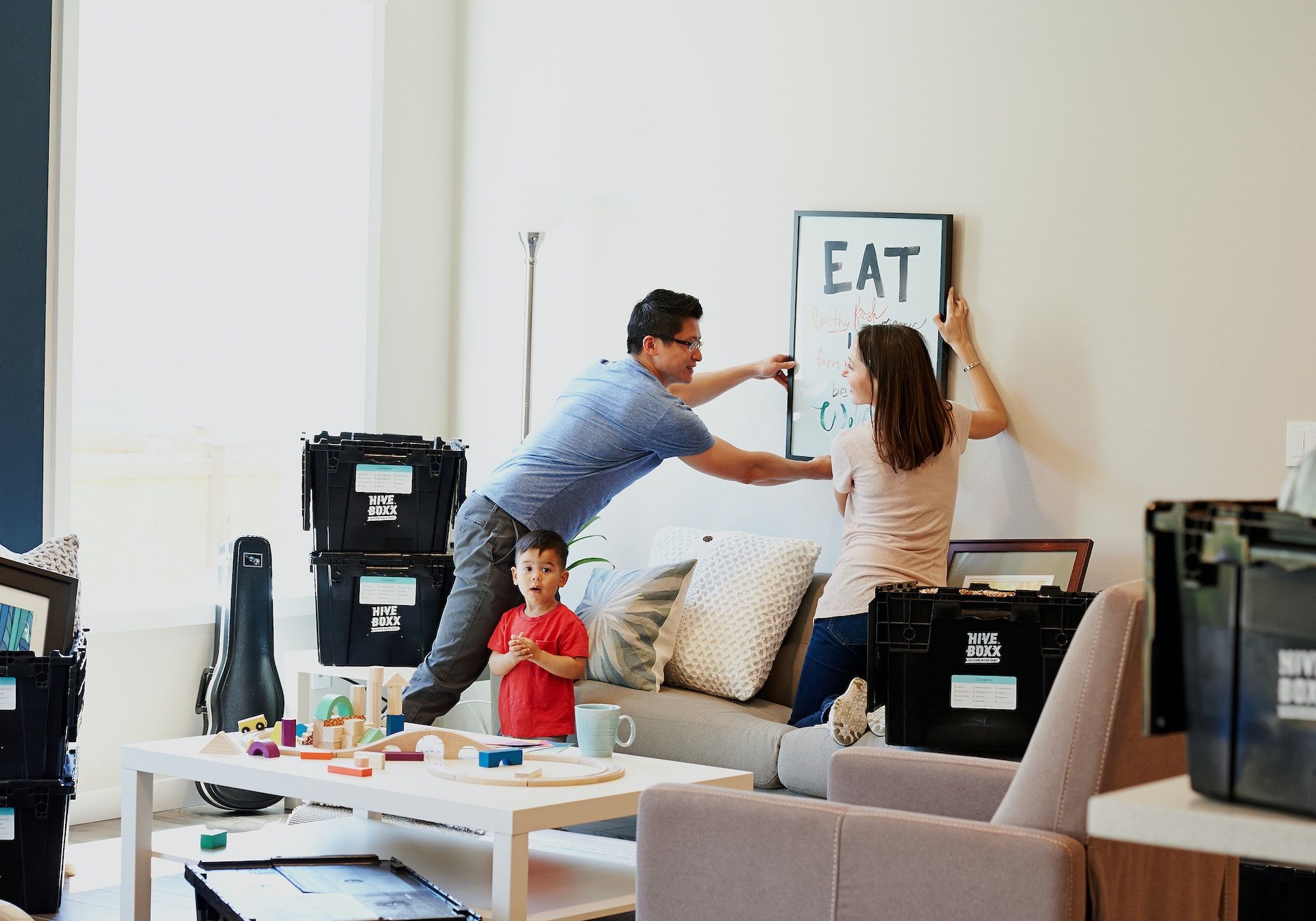 Family putting a frame on wall