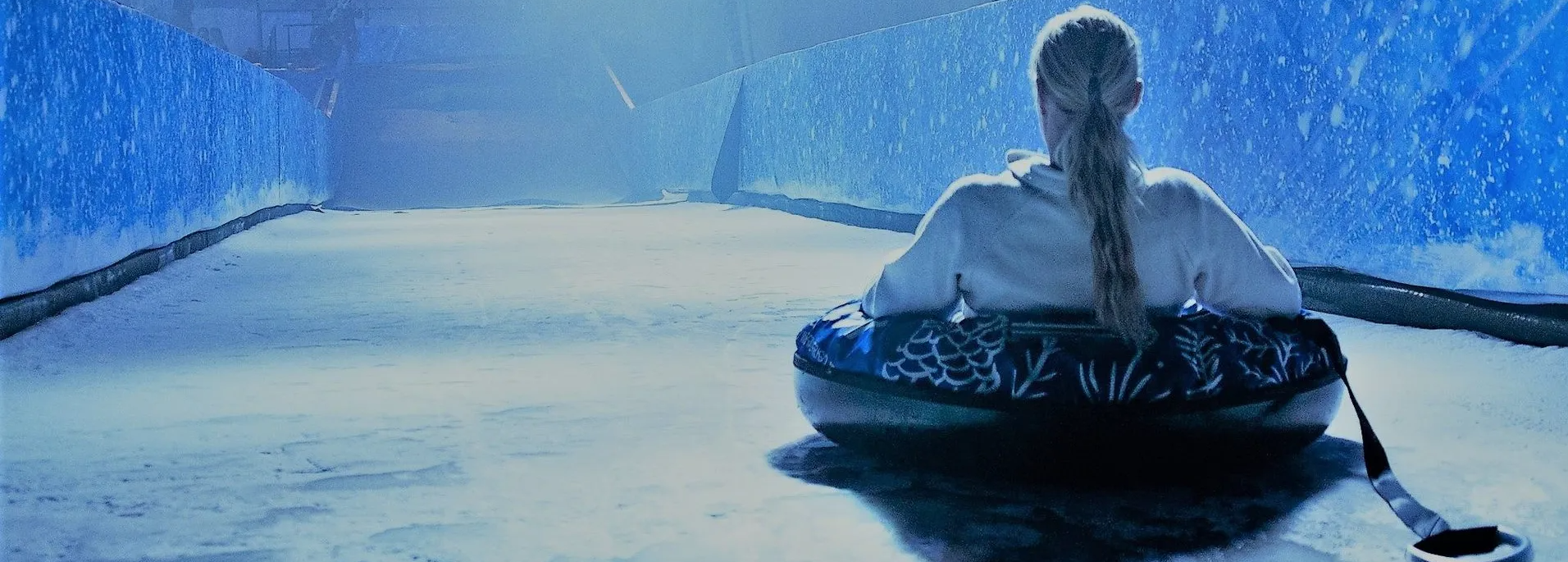View of ice slide from above with rider waiting to take the plunge at the top