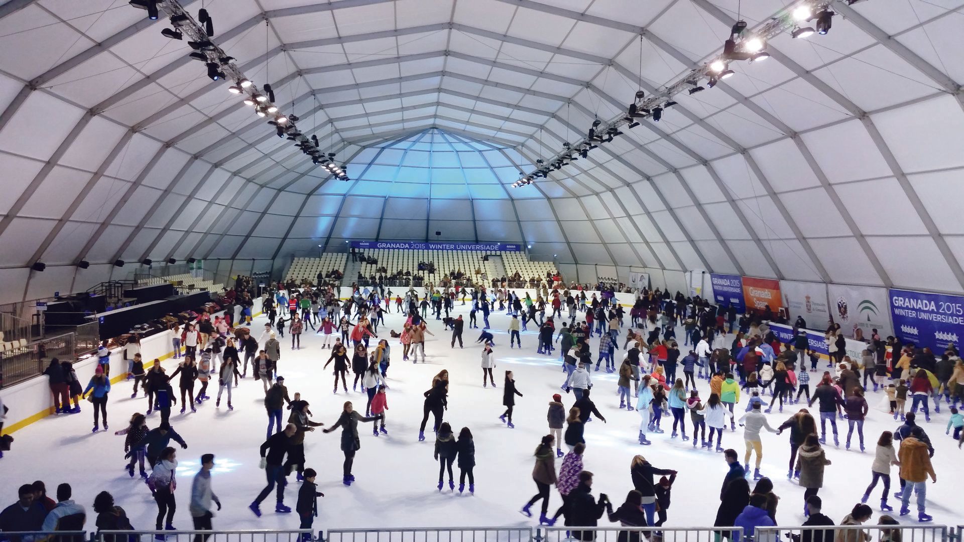 Leisure skating under a large domed structure.