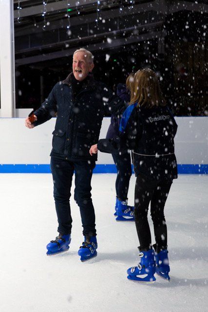 Two skaters on an ice rink with falling snow