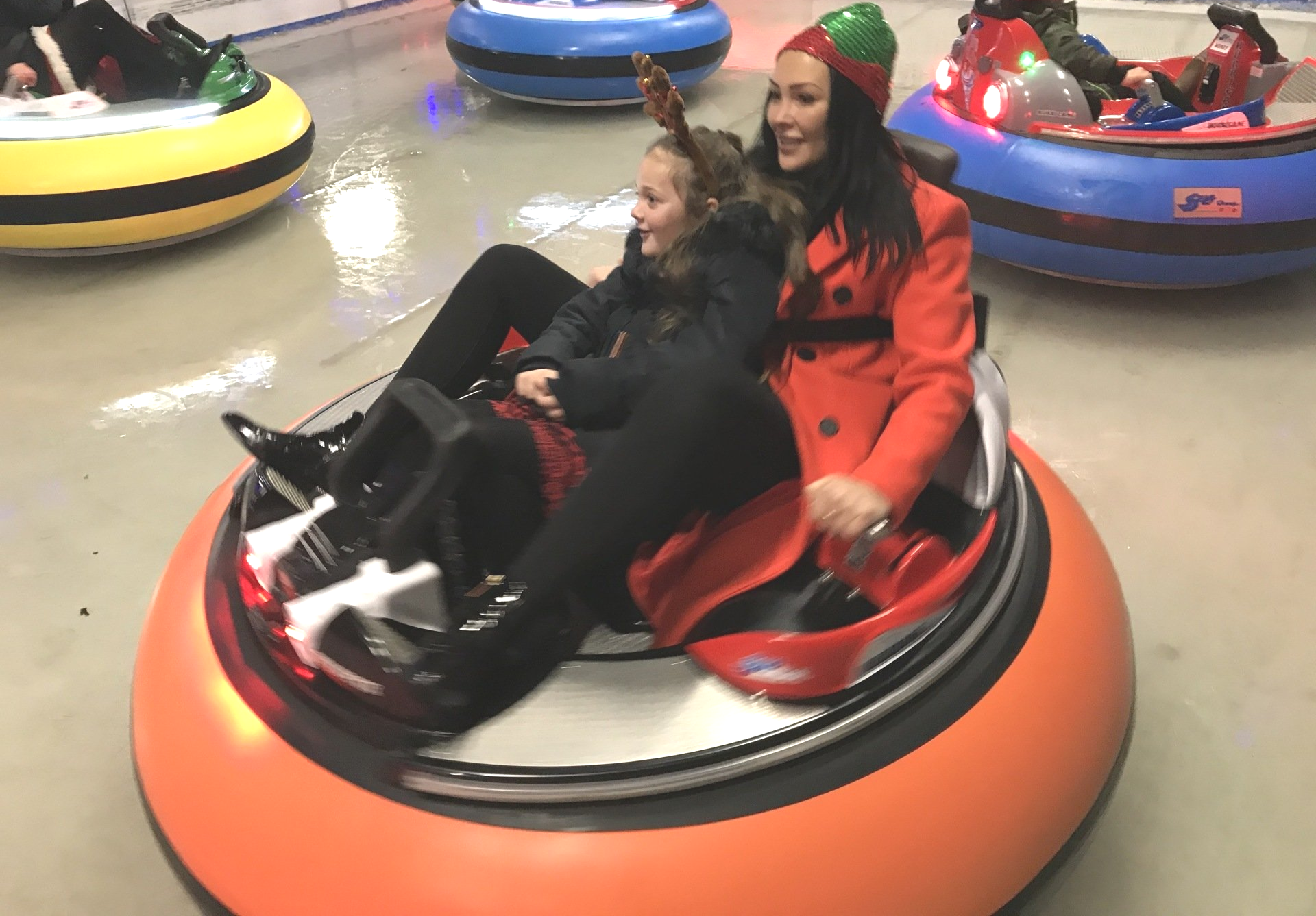 Inflatable bumper cars on ice, woman with red winter coat and child in black winter coat
