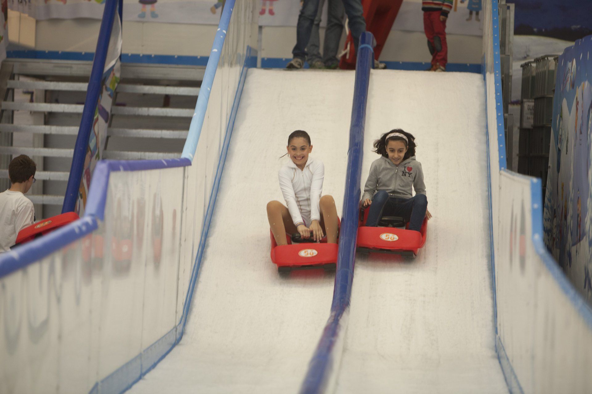 Bright red mini bob sled with rider racing down