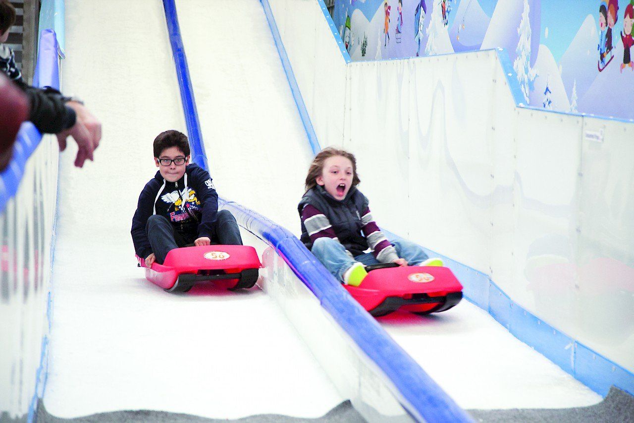 Bright red mini bob sled with rider racing down