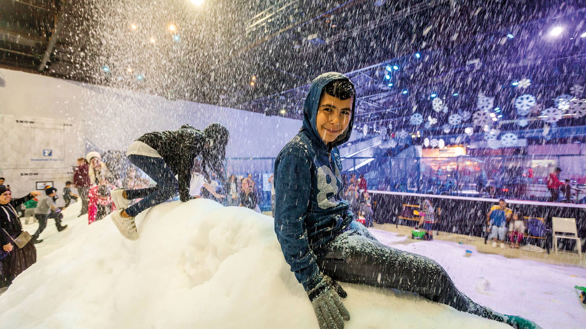 Young boy with broad smile on a pile of snow