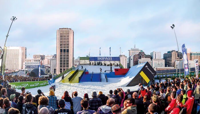 Outdoor snow slope with people skiing and snowboarding down