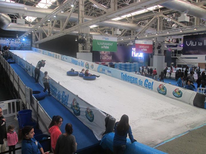 Huge wide and long slide with children racing down in inflatable donuts