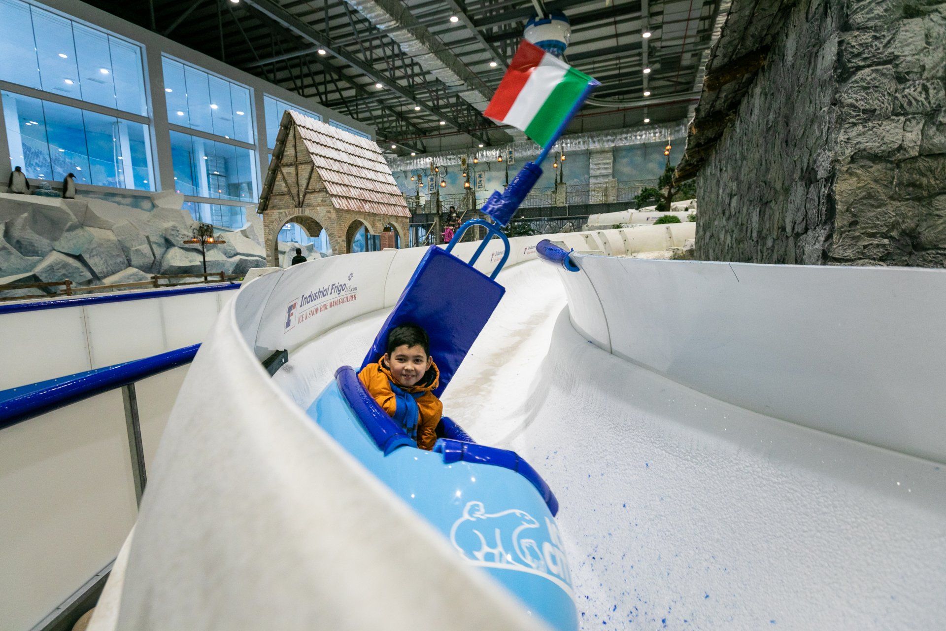 Bright blue bob sled with rider racing down