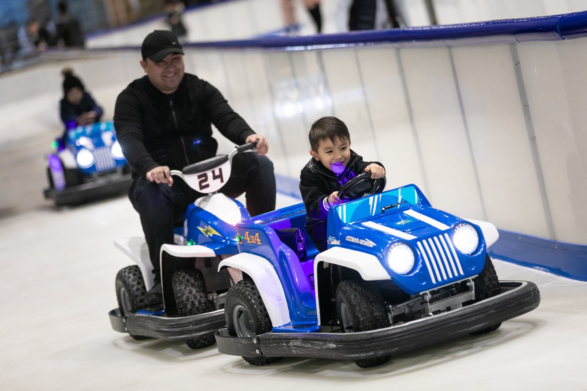 Blue ice car and ice bike with smiling riders. Dad and son.