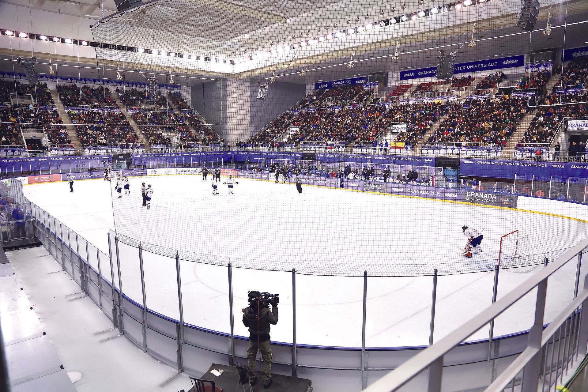 Full size ice hockey rink with players and huge seated crowd
