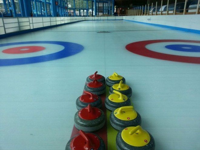 Close up of curling stones and targets