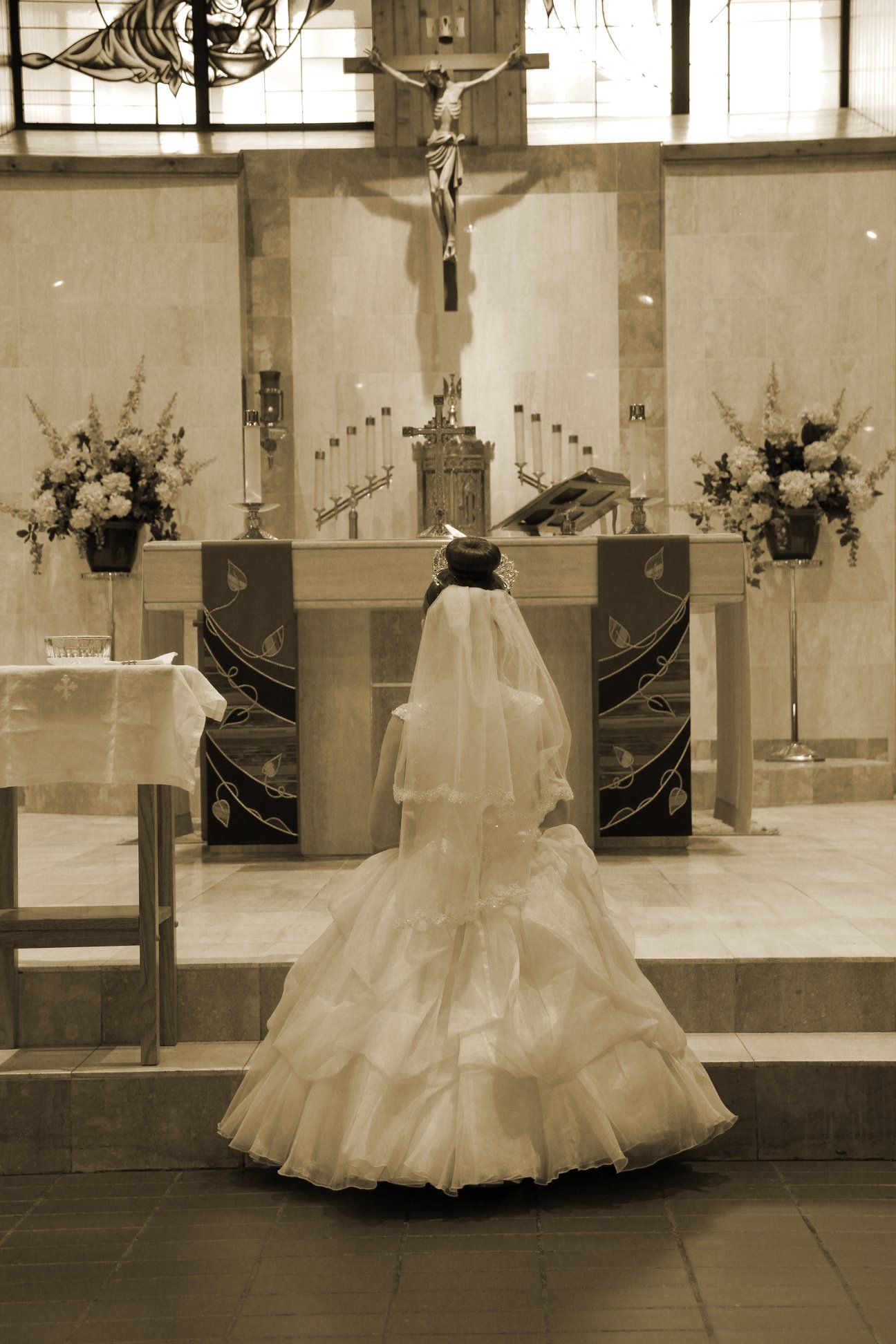 A young girl in a communion dress at the alter in a church.