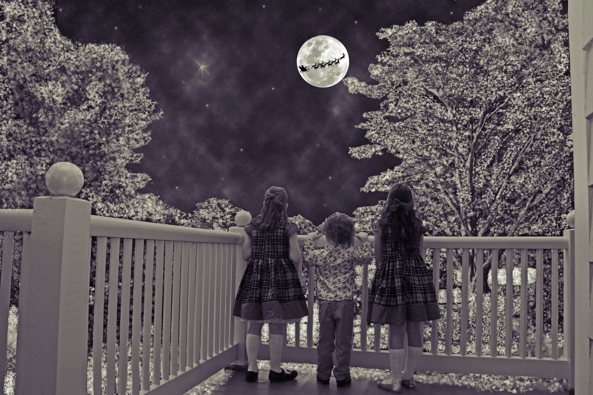 A black and white image of three children looking at the moon.