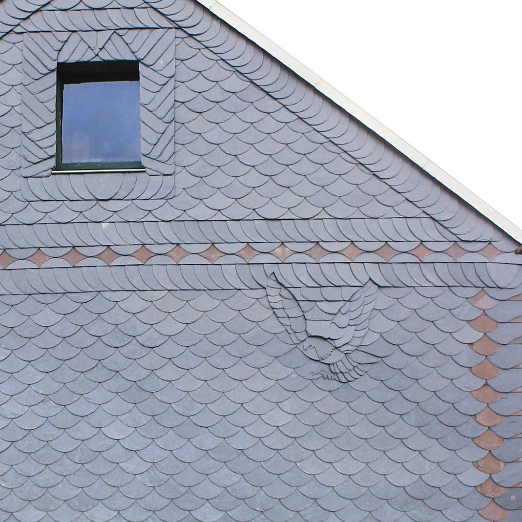 Fassadenbekleidung mit Schieferbild Adler Schmuckband aus rotem Schiefer.