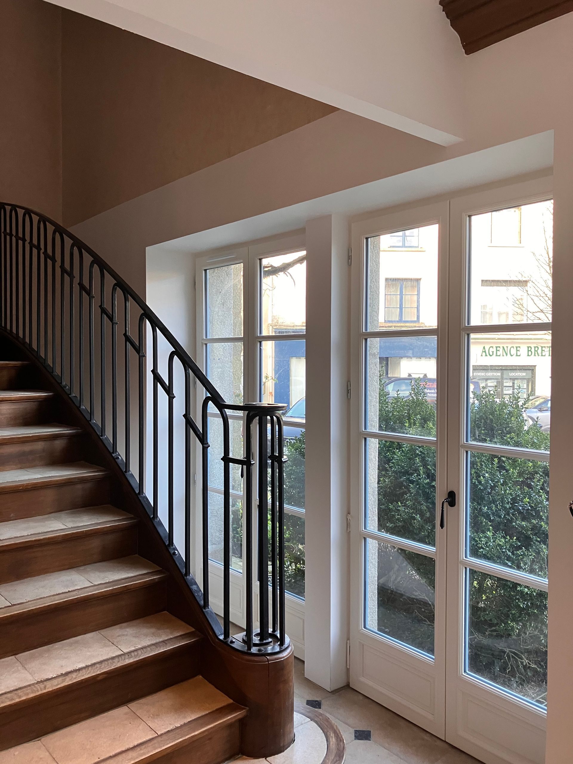 Escalier intérieur et nouvelles menuiseries vitrées apportant lumière naturelle et ouverture sur l’extérieur