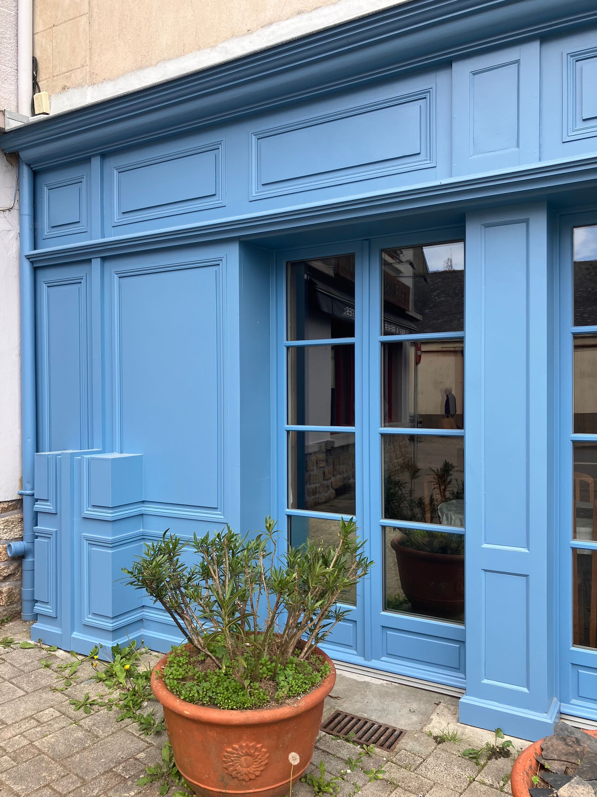Détail de menuiseries extérieures rénovées avec modénatures et boiseries bleues sur façade commerciale