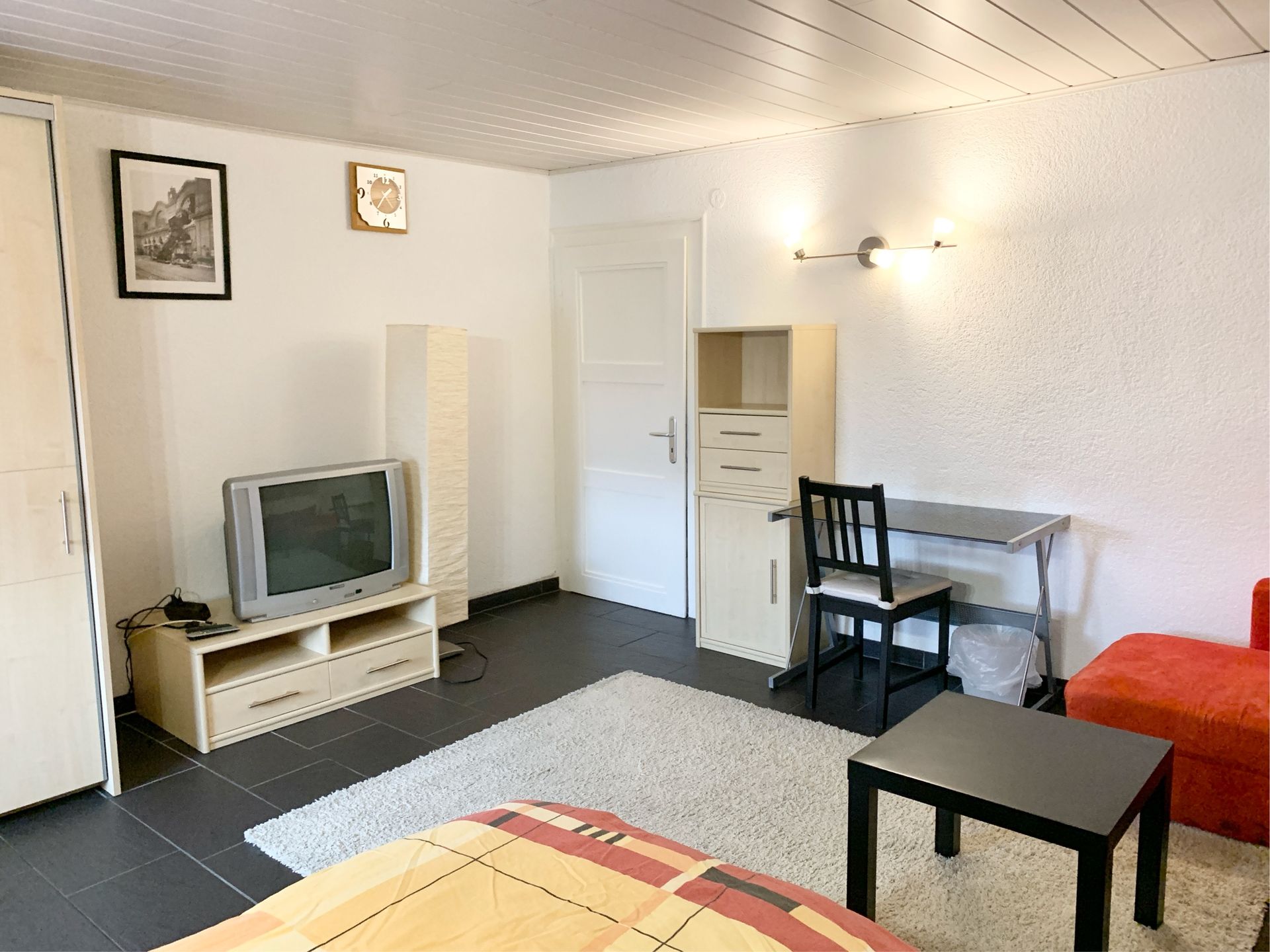 Beispielzimmer für Monteure mit Bett, Schreibtisch und Flachbildfernseher.