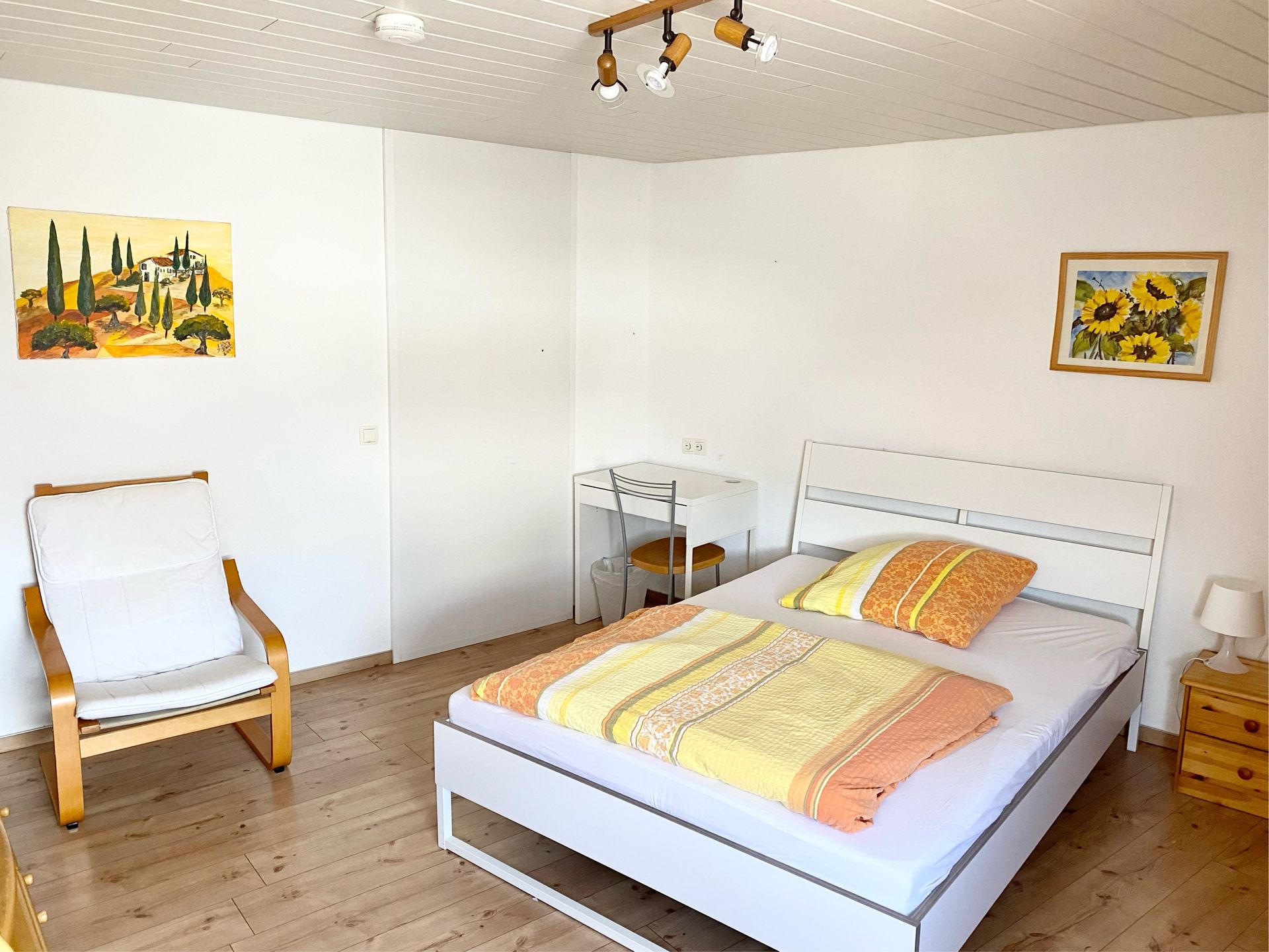 Möbliertes Einzelzimmer mit Bett, Schreibtisch, Kleiderschrank und TV.
