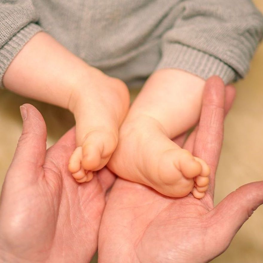 Babyfüße in Frauenhänden