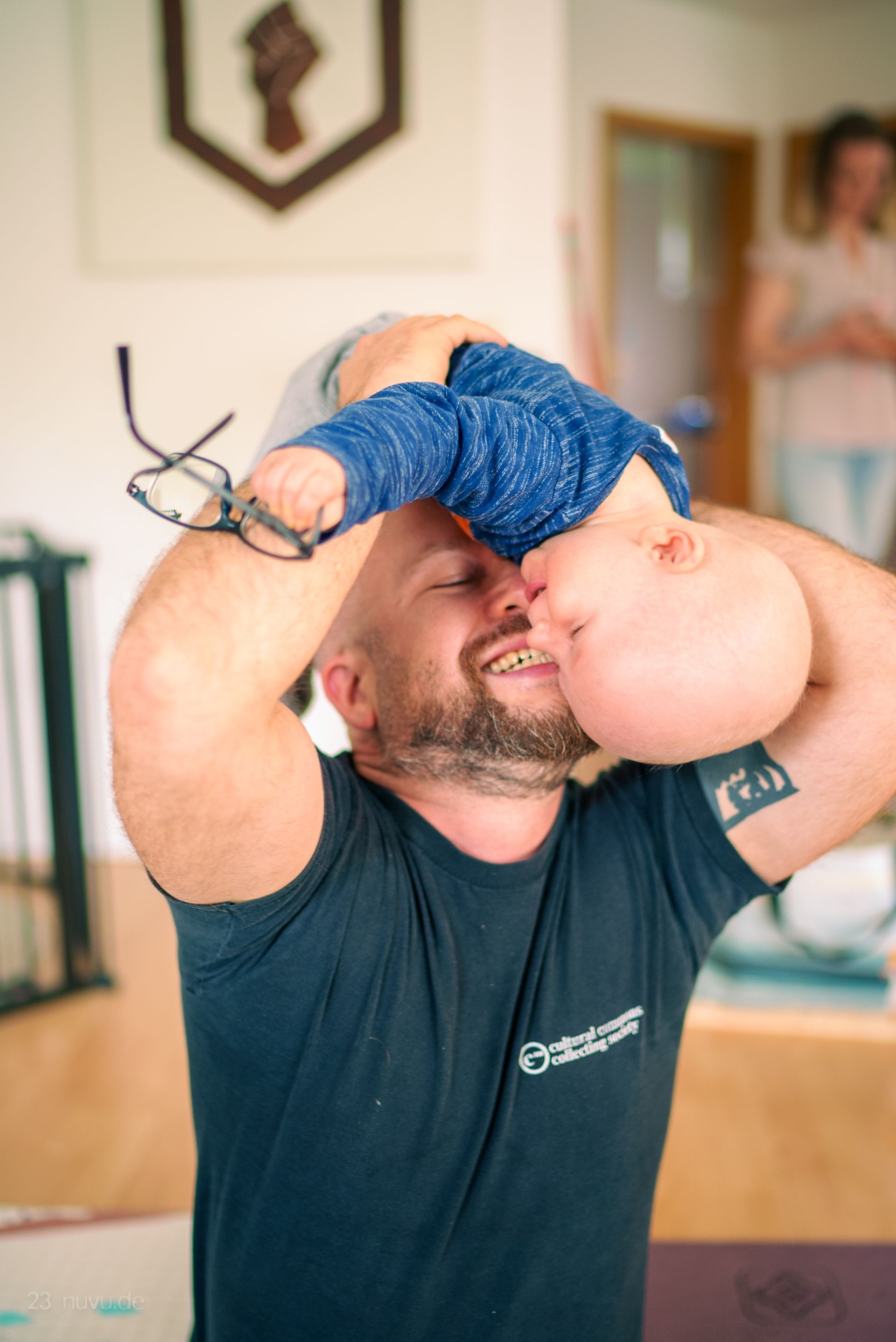 Man in schwarten t-Shirt mit Baby lachend