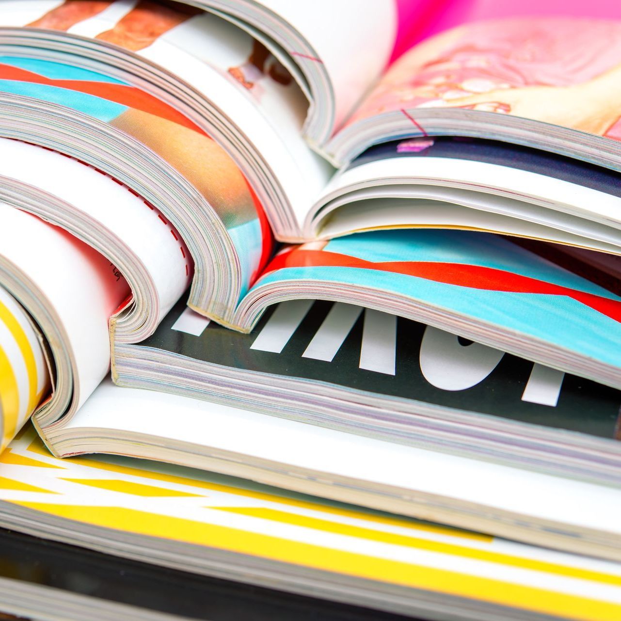 Formatfüllende, aufgeschlagene, bunt bedruckte Zeitschriften