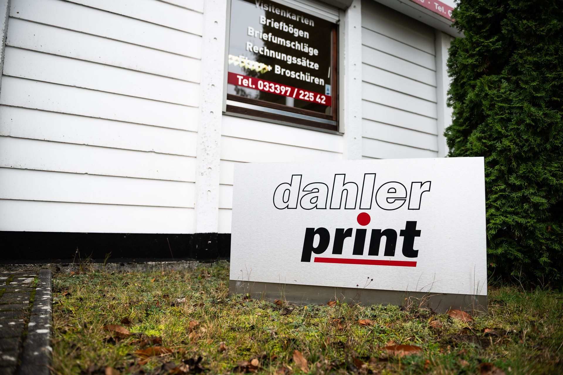 Man sieht ein Firmenschild mit dem Aufdruck Dahler Print vor dem Firmengebäude der Druckerei.
